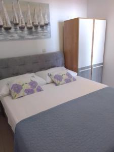 een slaapkamer met een groot bed met 2 kussens bij Apartments Dida in Hvar