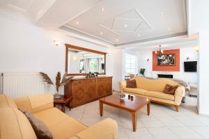 a living room with two couches and a table at Aegean Whispers House in Psalidi