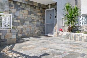 a front door of a house with a stone wall at Aegean Whispers House in Psalidi +37 photos