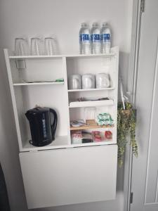 een witte koelkast met een deur open met flessen water bij Posyrooms in Manchester