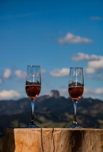 dos copas de vino sentadas en la cima de una cornisa en Chalé Magia do Serrano, en São Bento do Sapucaí