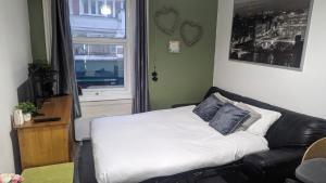 a bed in a room with a couch and a window at Homely Apartment in the Heart of Town Centre - Sleeps 6 in Bournemouth