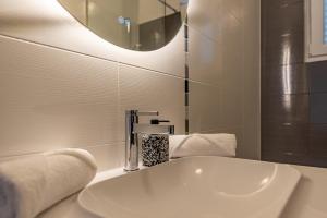 uma casa de banho com um lavatório branco e um espelho. em Apartments L&D em Biograd na Moru