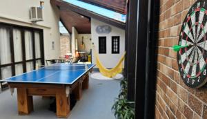 a room with a ping pong table and a dartboard at Beach Guest House - GMT in Rio de Janeiro