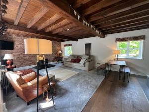 a living room with a brick wall and wooden ceilings at The Old Barn in Market Rasen