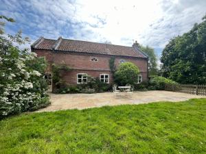 a brick house with a patio in the yard at The Old Barn in Market Rasen