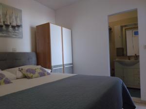 a bedroom with a bed and a cabinet and a sink at Apartments Dida in Hvar