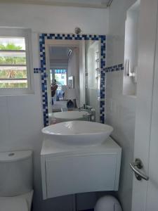 a bathroom with a sink and a toilet and a mirror at Marazul D1 in Westpunt