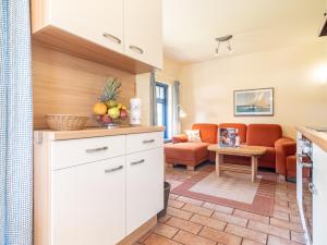 a kitchen and living room with a couch at Ferienhaussiedlung Strandperlen Weidenhof 6b (Typ IX) in Wustrow