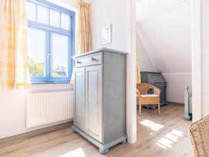 a room with an old cabinet in front of a window at Ferienhaussiedlung Strandperlen Weidenhof 6b (Typ IX) in Wustrow