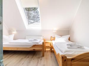 Duas camas num quarto com uma clarabóia em Ferienhaussiedlung Strandperlen Weidenhof 6b (Typ IX) em Wustrow