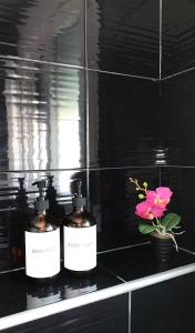 three bottles of soap on a counter with a flower at Chrystal Boutique Suite in Skala Marion