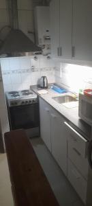 uma cozinha branca com um fogão e um lavatório em Corrientes y Uruguay em Buenos Aires