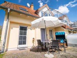 a table with an umbrella in front of a house at Strandoase Typ STO-A STRANDOASE Whg. SO5 in Wustrow