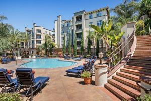 ロサンゼルスにあるModern 2bedroom Apartment with Poolのラウンジチェアと建物のあるスイミングプール