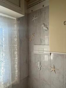 a bathroom with a shower with starfish on the wall at CASA GUGHI in Rapallo