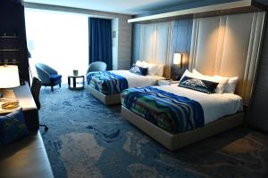 um quarto de hotel com duas camas e uma cadeira em Muckleshoot Casino Resort em Auburn