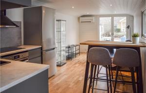 博里霍尔姆Gorgeous Home In Borgholm With Wifi的酒吧内的厨房,配有柜台和两个凳子