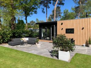 een patio met twee banken in een tuin bij Huisje in Stijl in Ermelo