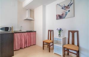uma cozinha com um balcão, 2 cadeiras e um lavatório em Gorgeous Apartment In Baena With House A Panoramic View em Baena