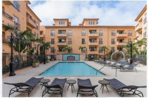 una piscina con sillas y un edificio en Modern 2bedroom Apartment with Pool en Los Ángeles