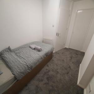 a small bedroom with a bed with a towel on it at Beautiful place near Dagenham East Station in Dagenham