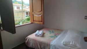 a bedroom with a bed with two pairs of shoes on it at Orquideas 3 in Jericó