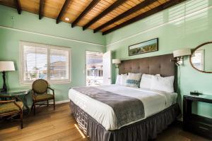 Dormitorio con cama, escritorio y TV en Pleasant Inn en Morro Bay