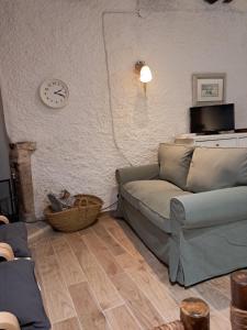 a living room with a couch and a clock on the wall at Lo Cremallé in Valderrobres