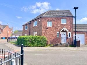 a brick house with a white door on a street at Payler House Sheffield-WiFi -Large Parking Space-cozy 4 bedrooms in Sheffield