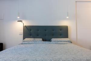 - un grand lit avec une tête de lit bleue dans une chambre dans l'établissement Tropicana Suite - Adults Only, à Agropoli
