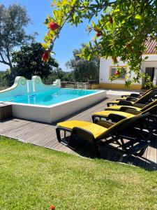 una piscina con sedie a sdraio in un cortile di Monte dos Caramelos a Santiago do Cacém