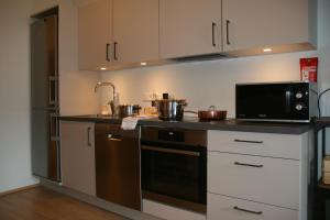 a kitchen with a microwave oven and a stove at Puffin Nest, Superior Apartment in Reykjavík