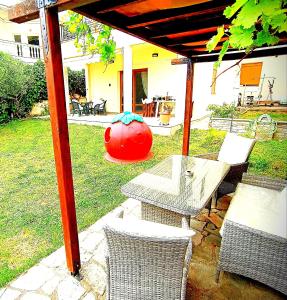 um pátio com uma mesa e cadeiras sob uma pérgola em villa panorama seaview em Tessalônica