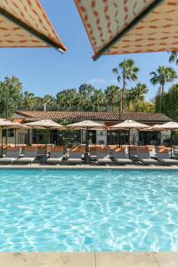 uma piscina num resort com cadeiras e guarda-sóis em Estancia La Jolla Hotel & Spa em San Diego