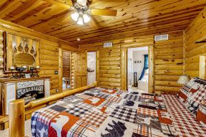a log cabin bedroom with a bed and a fireplace at Getaway on the Green in Arkdale
