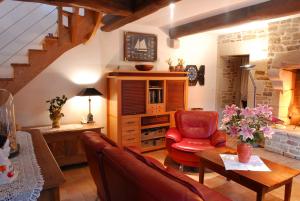 a living room with a red chair and a table at Domaine de Kervail in Quimperlé