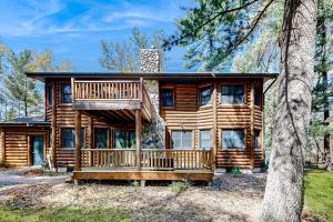 a log cabin in the woods with a deck at Getaway on the Green in Arkdale