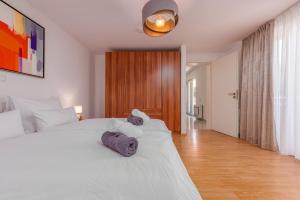 Un dormitorio con una cama blanca con toallas. en Apartments L&D en Biograd na Moru