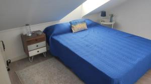 a bedroom with a blue bed and a night stand at Seixal Yachting Bay Apartments in Seixal