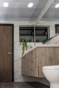ein Badezimmer mit einem Waschbecken, einem WC und einem Spiegel in der Unterkunft Hospedaje juandi in Medellín