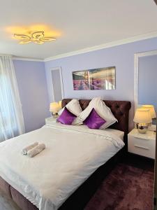 ein Schlafzimmer mit einem großen Bett mit lila Kissen in der Unterkunft Charming apartment with Garden, Free Parking near Basel, Airport, Ger'many, France, in Saint-Louis