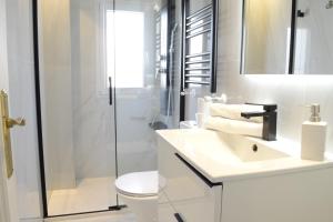 マドリードにあるBonito Apartamento Madrid Rioの白いバスルーム(シンク、シャワー付)