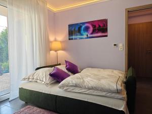 ein Schlafzimmer mit einem Bett mit lila Kissen in der Unterkunft Charming apartment with Garden, Free Parking near Basel, Airport, Ger'many, France, in Saint-Louis