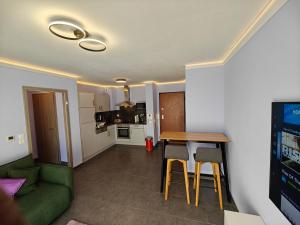 ein Wohnzimmer und eine Küche mit einem Tisch und Stühlen in der Unterkunft Charming apartment with Garden, Free Parking near Basel, Airport, Ger'many, France, in Saint-Louis