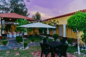 a patio with a table and an umbrella at Conceptos Campestre in Huehuetenango