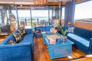 a living room with blue couches and a table at PEZ HOUSE in Pichilemu