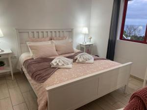 ein Schlafzimmer mit einem großen Bett mit zwei Kissen darauf in der Unterkunft Sunflower Guest House - Pico in São Caetano