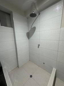 cabina de ducha a la sombra de un cabezal de ducha en Departamento Amoblado Vista Externa, en Huánuco