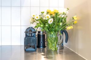 een vaas gevuld met gele en witte bloemen op een toonbank bij The Sands - Apartment 19 in Onetangi